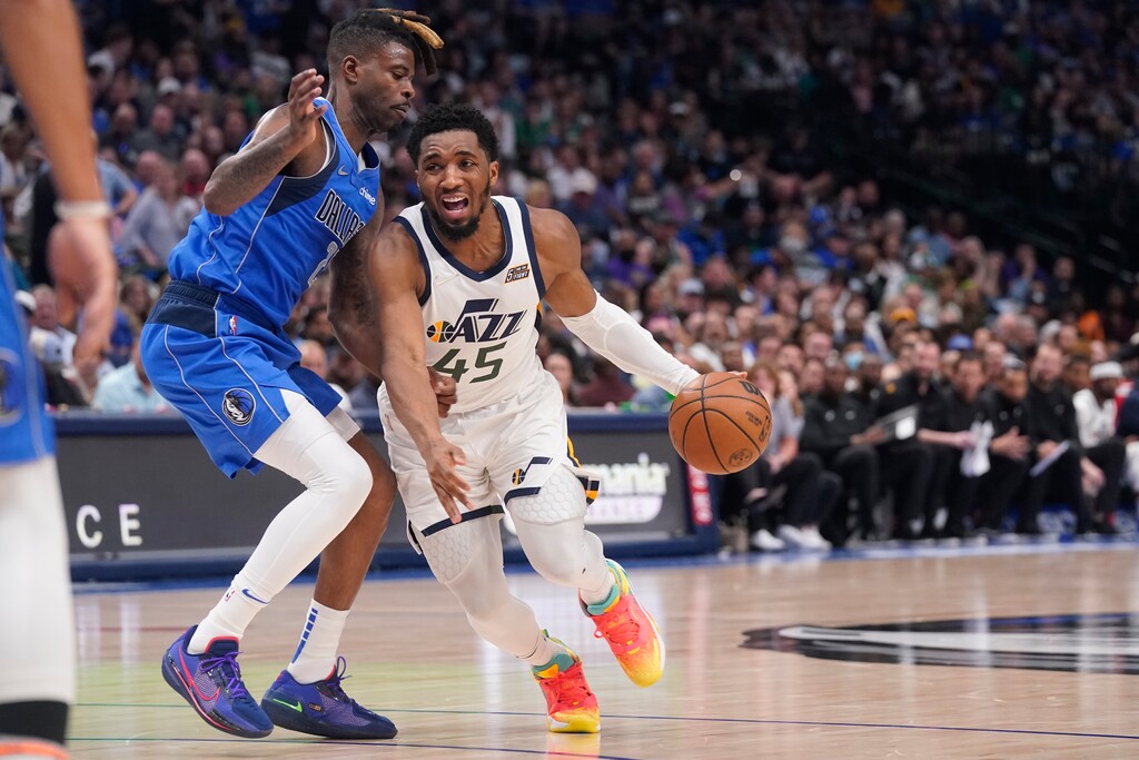 Utah Jazz guard Donovan Mitchell (45) drives against Dallas Mavericks forward Reggie Bullock (25) during the first half of an NBA basketball game in Dallas, Sunday, March 27, 2022. (AP Photo/LM Otero)