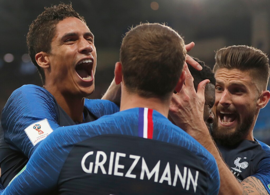 French players mob France's Samuel Umtiti after he scored the opening goal of the game during the semifinal match between France and Belgium at the 2018 soccer World Cup in the St. Petersburg Stadium in, St. Petersburg, Russia, Tuesday, July 10, 2018. (AP Photo/Natacha Pisarenko)