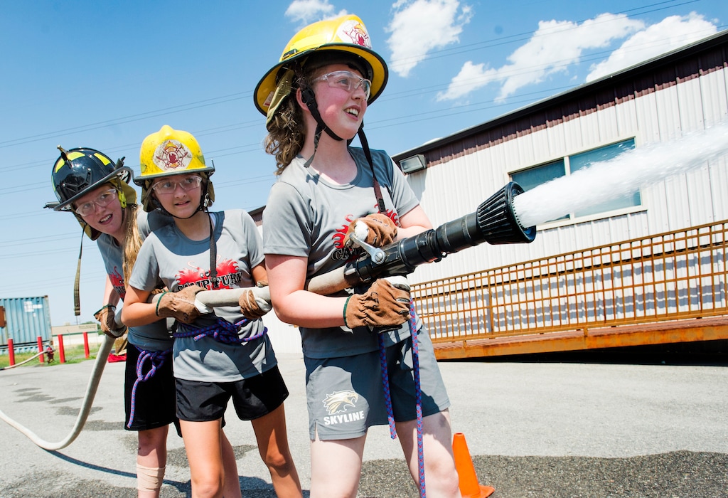 (Rick Egan  |  The Salt Lake Tribune)  Liz Nicole and Annika spray water from a firehoses while competing in a fire fighter skills relay, while attending Camp Fury.  A dozen Utah Girl Scouts participated in a 3-day camp led by female firefighters. Camp Fury Utah was developed in partnership with the Girl Scouts and local fire and police departments, designed to expose teen girls to careers in public safety and other non-traditional jobs. Saturday, August 5, 2017.