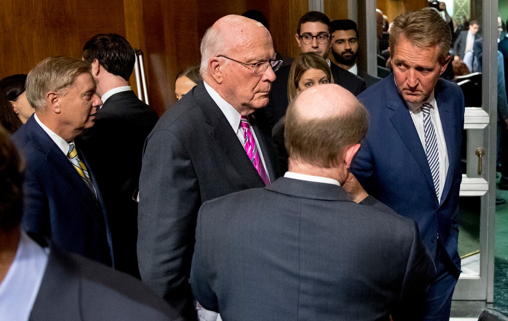 (Andrew Harnik | The Associated Press) Sen. Jeff Flake, R-Ariz., right, speaks with Patrick Leahy, D-Vt., third from right, and Sen. Chris Coons, D-Del., second from right, at the conclusion of a Senate Judiciary Committee hearing on Capitol Hill in Washington, Friday, Sept. 28, 2018, after Flake calls for an FBI investigation into the allegations brought forward against Supreme Court nominee Judge Brett Kavanaugh. The committee voted along party lines to send the Kavanaugh nomination to the full Senate for a vote. Also pictured is Sen. Lindsey Graham, R-S.C., left.