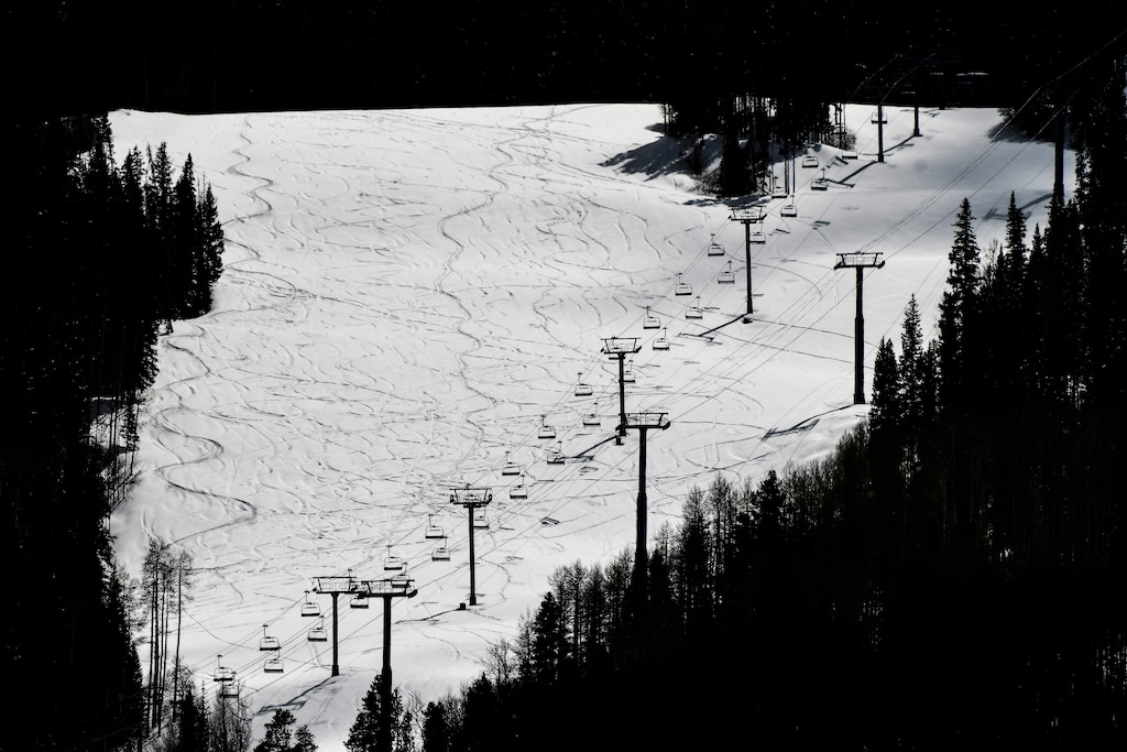 This Tuesday, March 24, 2020 photo shows ski lifts empty in Vail, Colo., after Vail Ski Resort closed for the season amid the COVID-19 pandemic. The closure has ended the normally busy spring ski season more than a month early. (AP Photo/Michael Ciaglo)