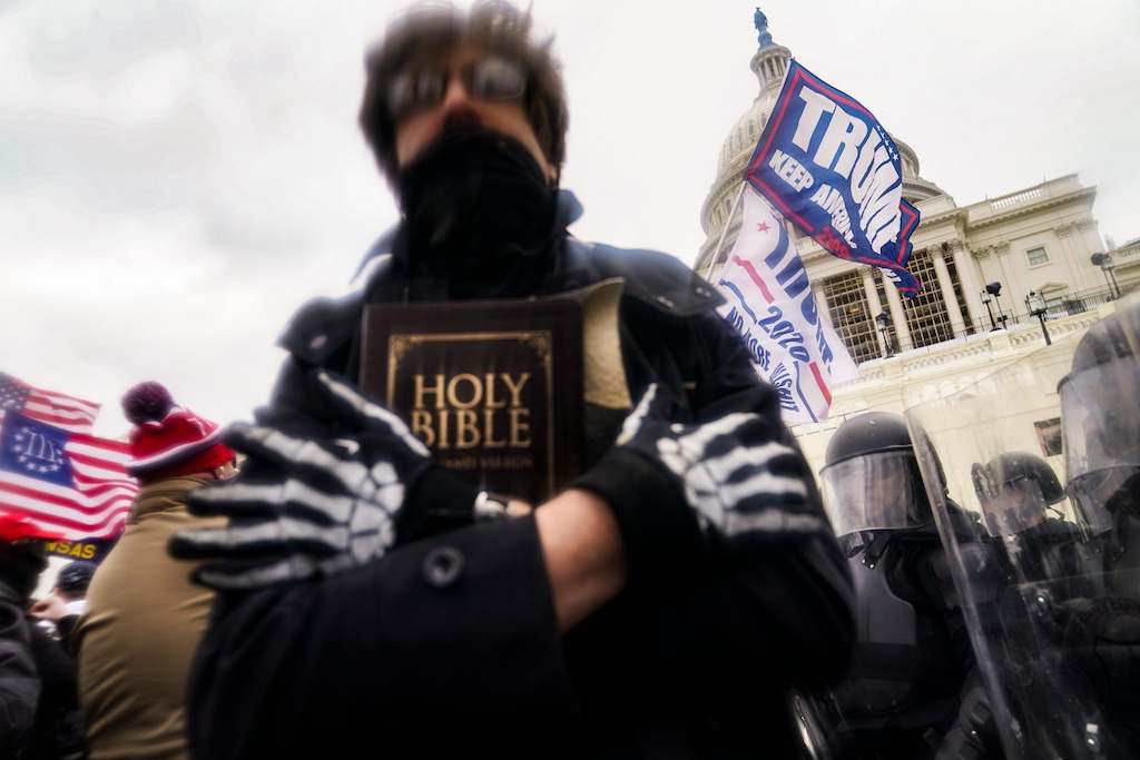(John Minchillo | AP) In this Wednesday, Jan. 6, 2021 file photo, a man holds a Bible as Trump supporters gather outside the Capitol in Washington.