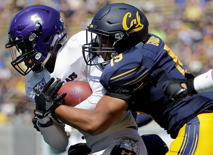 Weber State wide receiver TyJuan Prince, left, is grabbed by California linebacker Cameron Goode before fumbling the ball during the first half of an NCAA college football game in Berkeley, Calif., Saturday, Sept. 9, 2017. California recovered the fumble. (AP Photo/Jeff Chiu)