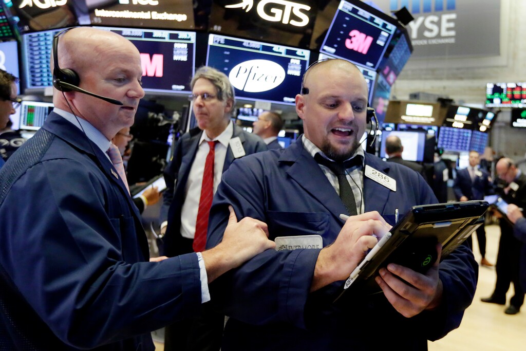 Traders Patrick Casey, left, and Michael Milano work on the floor of the New York Stock Exchange, Tuesday, Aug. 28, 2018. Stocks are opening broadly higher on Wall Street as stocks add to the records they've set in the last few days. (AP Photo/Richard Drew)
