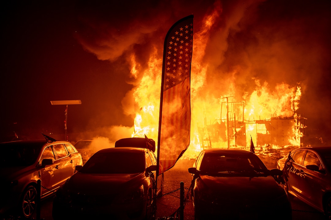 (Noah Berger | The Associated Press) Flames consume a car dealership as the Camp Fire tears through Paradise, Calif., on Thursday, Nov. 8, 2018. Tens of thousands of people fled a fast-moving wildfire Thursday in Northern California, some clutching babies and pets as they abandoned vehicles and struck out on foot ahead of the flames that forced the evacuation of an entire town and destroyed hundreds of structures.