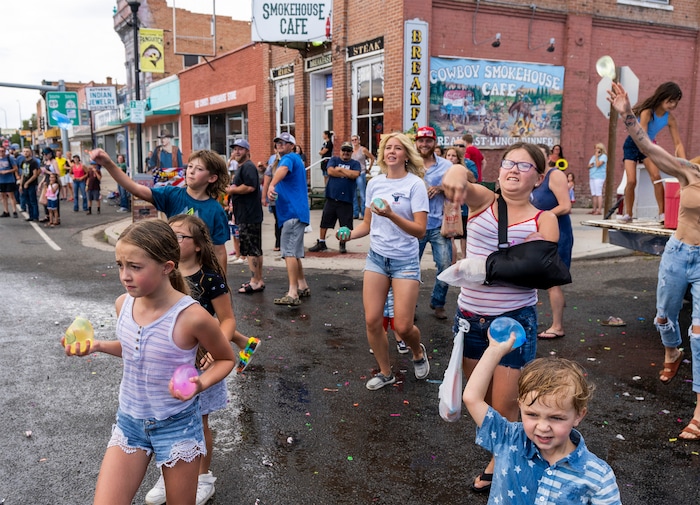 (Rick Egan | The Salt Lake Tribune) 
Parade goers hurl water balloons at one of the floats in the Pioneer Day Parade in Panguitch, on Saturday, July 23, 2022. 
