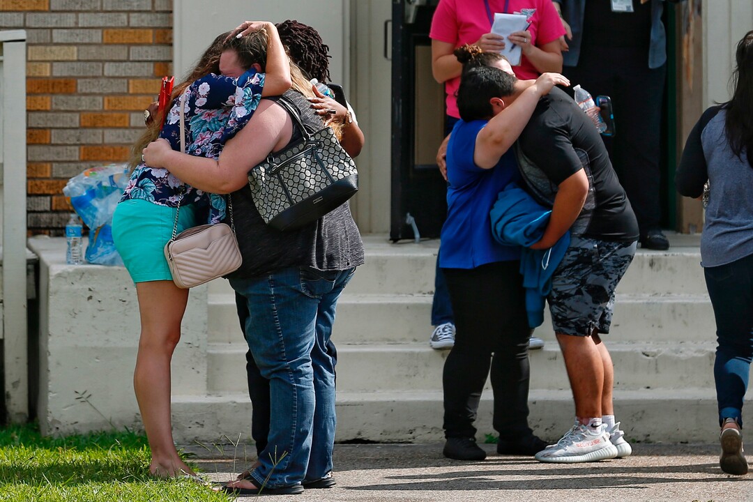 People embrace outside the Alamo Gym where students and parents wait to reunite following a shooting at Santa Fe High School Friday, May 18, 2018, in Santa Fe, Texas. ( Michael Ciaglo/Houston Chronicle via AP)