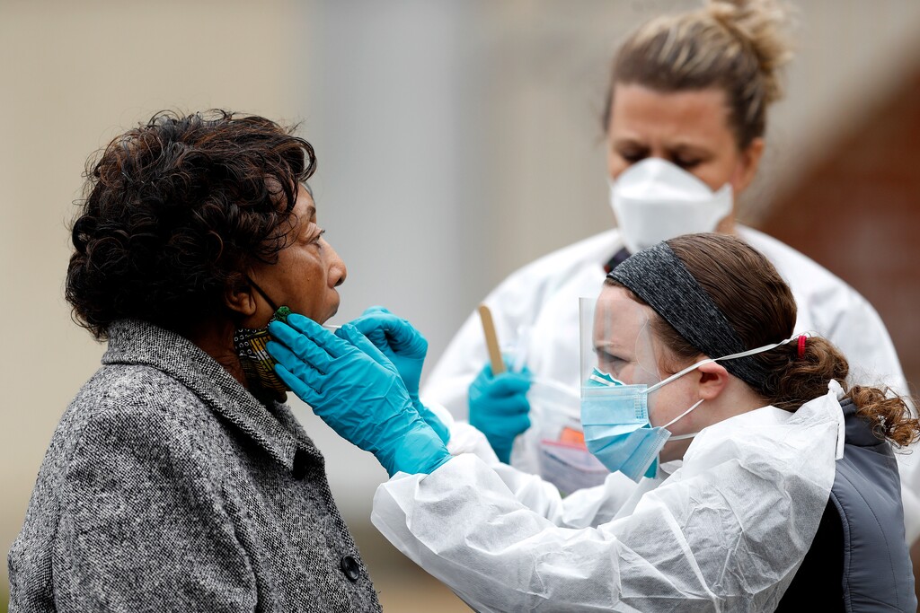 Alma Cropper, 84, left, is given a coronavirus test near her vehicle at a walk-up testing center, Monday, April 20, 2020, in Annapolis, Md. According to the City of Annapolis Office of Emergency Management, the testing site began with a limited number of tests for people with symptoms on Monday. (AP Photo/Julio Cortez)