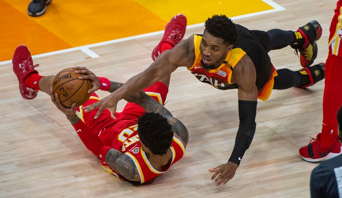 (Rick Egan | The Salt Lake Tribune) Utah Jazz guard Donovan Mitchell (45) dives for a loose ball, along with Atlanta Hawks forward John Collins (20), in NBA action between the Utah Jazz and the Atlanta Hawks at Vivint Arena, on Friday, Jan. 15, 2021.