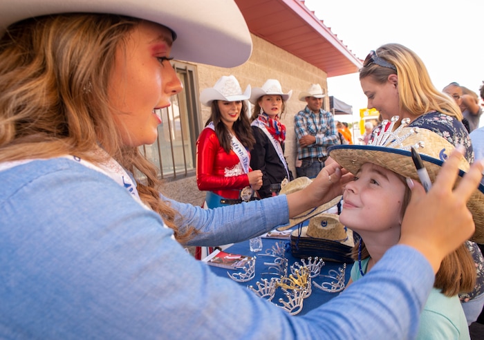 (Rick Egan  |  The Salt Lake Tribune)     Western Stampede Second attendant Madelyn Mundy, puts a crown and a free cowboy hat on Emma Ball, 8 from Syracuse, at the West Jordan Western Stampede Rodeo, Saturday, July 6, 2019.
