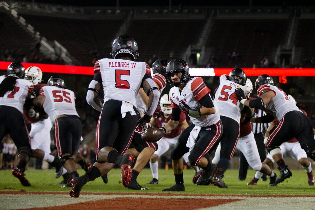 (D. Ross Cameron | AP) Utah quarterback Cameron Rising hands off to running back TJ Pledger (5) during the second quarter of the team's NCAA college football game against Stanford, Friday, Nov. 5, 2021, in Stanford, Calif. Pledger ran 96 yards for a touchdown.