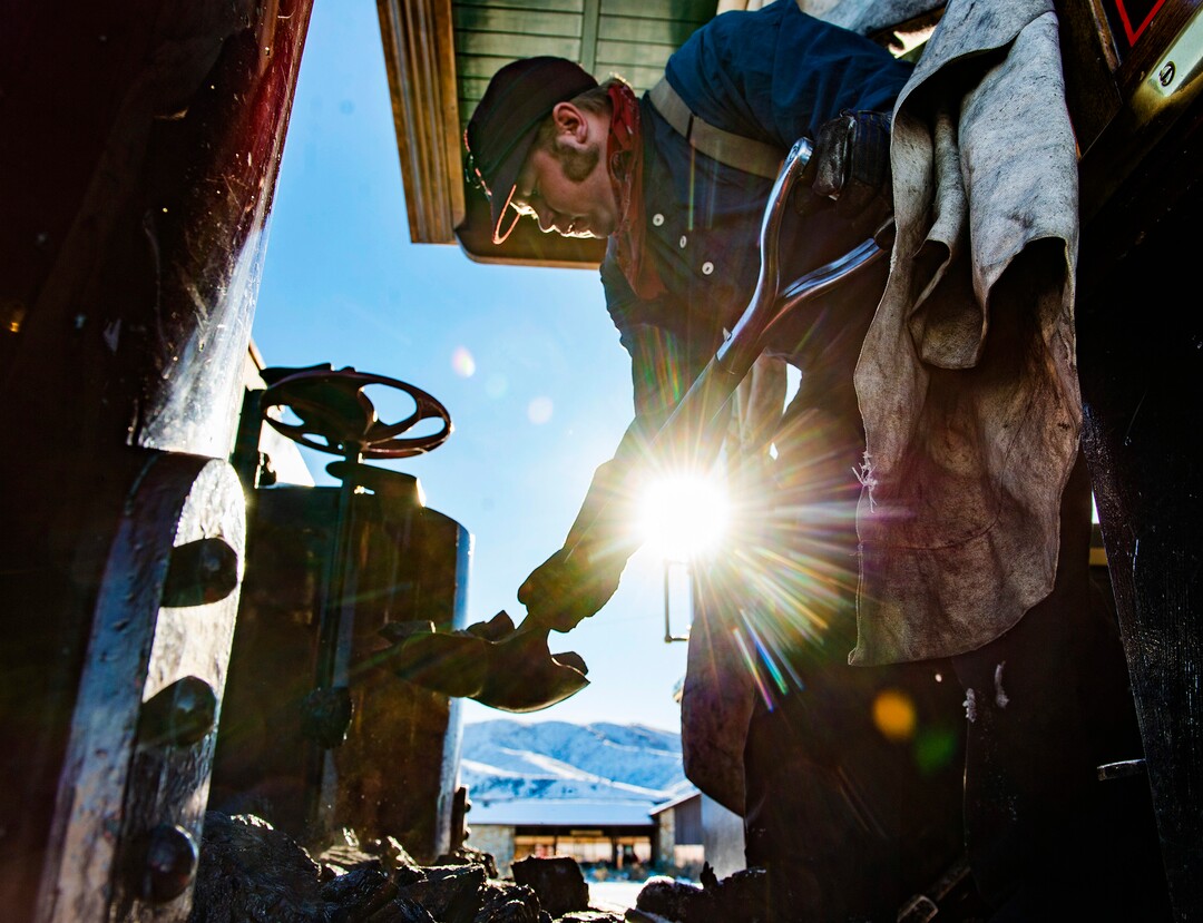 (Rick Egan | The Salt Lake Tribune) Locomotive Engineer, Tom Brown shovels coal on the 119 Steam Engine, at the Golden Spike National Historical Park during a winter steam locomotive demonstration, on Tuesday, Dec. 29, 2020.