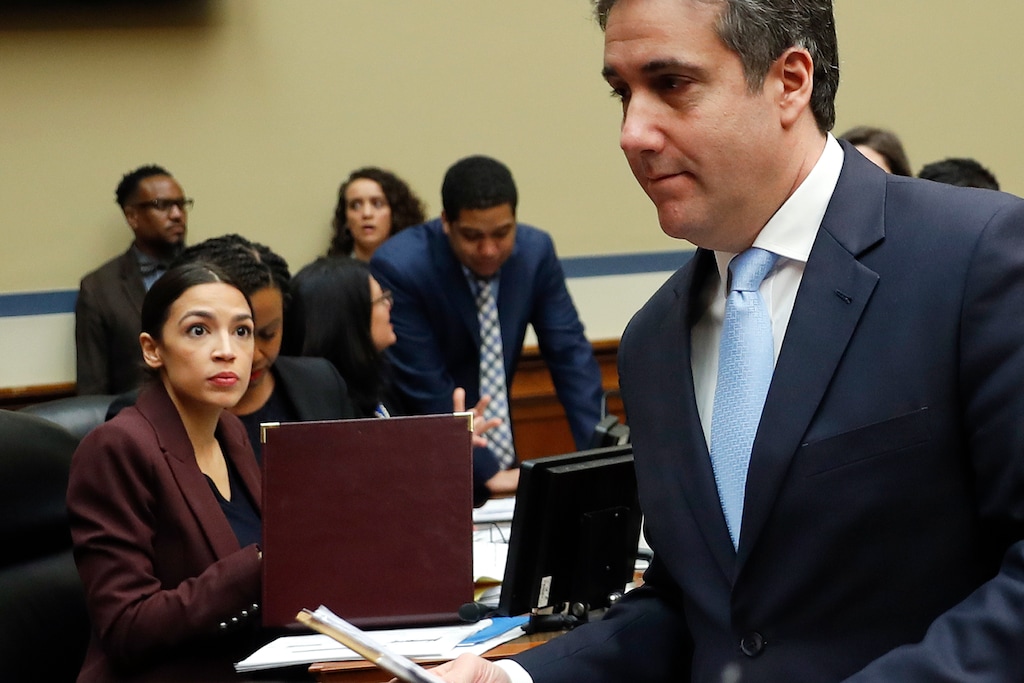 Michael Cohen, right, President Donald Trump's former lawyer, walks past committee member Rep. Alexandria Ocasio-Cortez, D-N.Y., center, during a break in Cohen's testimony before the House Oversight and Reform Committee on Capitol Hill in Washington, Wednesday, Feb. 27, 2019. (AP Photo/Pablo Martinez Monsivais)