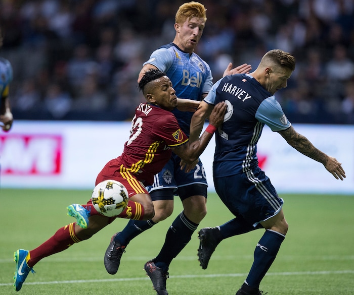 Real Salt Lake's Joao Plata, left, collides with Vancouver Whitecaps' Tim Parker, center, and Jordan Harvey during the first half of an MLS soccer match Saturday, Sept. 9, 2017, in Vancouver, British Columbia. (Darryl Dyck/The Canadian Press via AP)