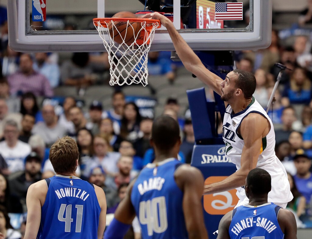 Utah Jazz center Rudy Gobert (27) dunks as Dallas Mavericks' Dirk Nowitzki (41), of Germany; Harrison Barnes (40); and Dorian Finney-Smith, right, watch during the first half of an NBA basketball game Thursday, March 22, 2018, in Dallas. (AP Photo/Tony Gutierrez)