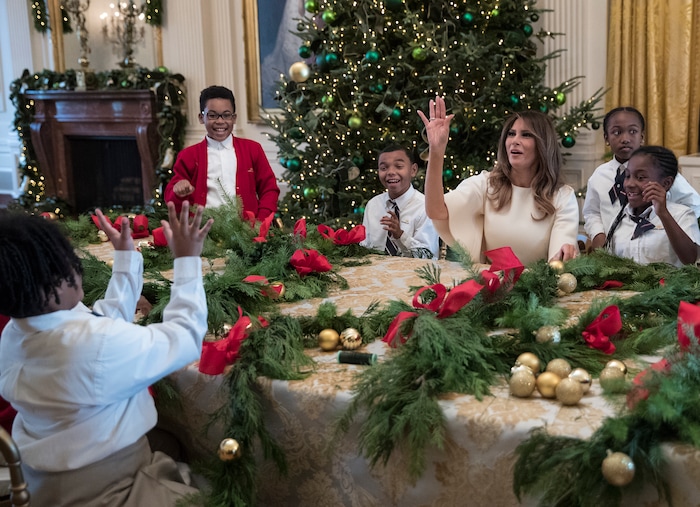 First lady Melania Trump tosses an ornament to a child across the table after one was tossed to her as she visits with children in the East Room among the 2017 holiday decorations with the theme "Time-Honored Traditions" at the White House in Washington, Monday, Nov. 27, 2017. The First Lady honored 200 years of holiday traditions at the White House. (AP Photo/Carolyn Kaster)