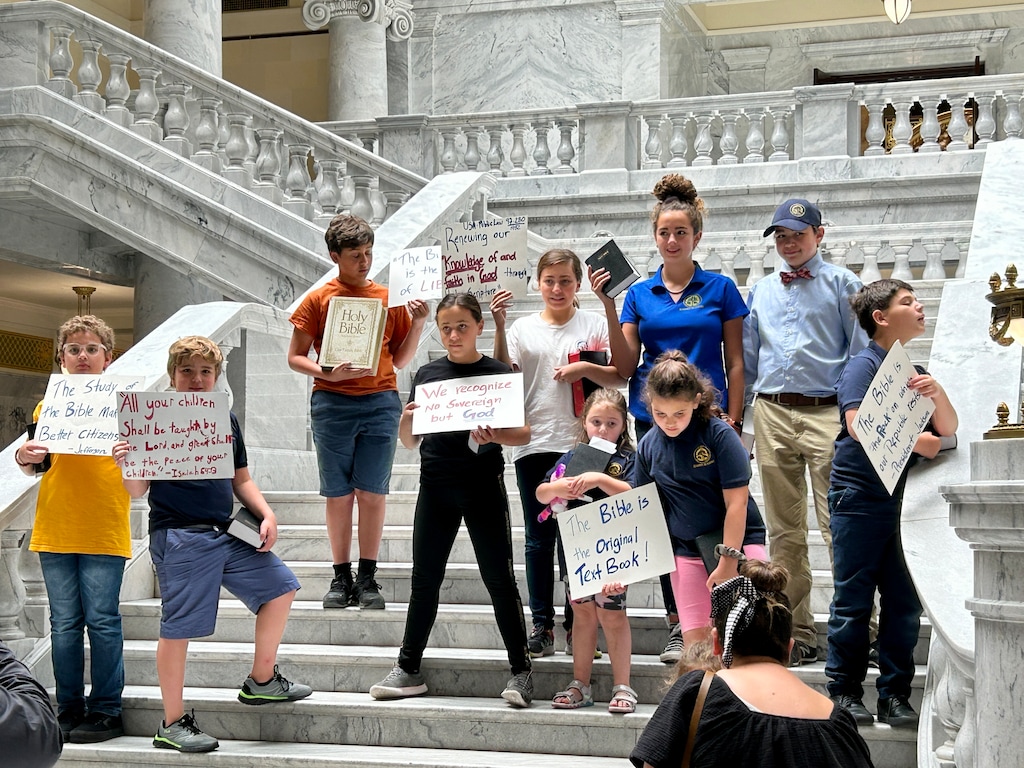 (Bryan Schott | The Salt Lake Tribune) Children hold signs protesting the decision to remove the Bible from some Davis County schools during a new conference at the Utah State Capitol on June 7, 2023.