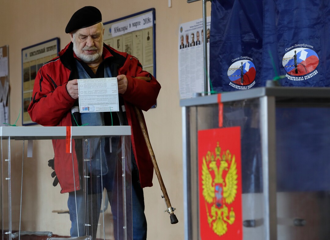 A man examines his ballot at a polling station during presidential elections in St.Petersburg, Russia, Sunday, March 18, 2018. Russians are voting in a presidential election in which Vladimir Putin is seeking a fourth term in the Kremlin. (AP Photo/Dmitri Lovetsky)
