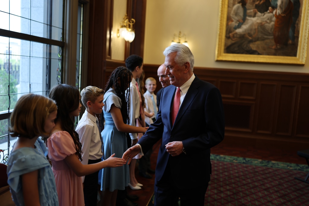 (The Church of Jesus Christ of Latter-day Saiints) Apostle Dieter F. Uchtdorf, followed by Utah Gov. Spencer Cox, greets members of a youth choir that performed at a media event Tuesday, Sept. 1, 2026, about the Salt Lake Temple reopening.