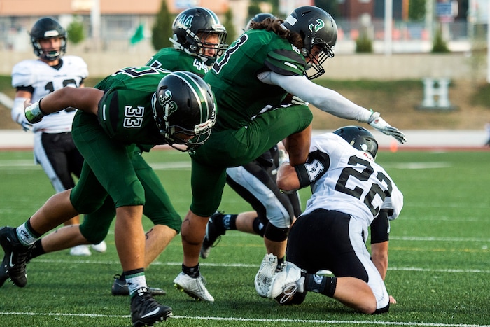 (Chris Detrick  |  The Salt Lake Tribune)    Hillcrest's Alex Cardona (3) scores a touchdown past Highland's Travis Boyce (22) during the game at Hillcrest High School Friday, September 1, 2017. 