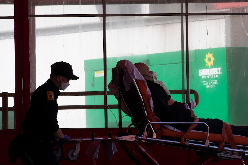 (Mary Altaffer | The Associated Press) Emergency medical technicians transport a patient to Elmhurst Hospital Center emergency room, Saturday, April 4, 2020 in the Queens borough of New York. The new coronavirus causes mild or moderate symptoms for most people, but for some, especially older adults and people with existing health problems, it can cause more severe illness or death.
