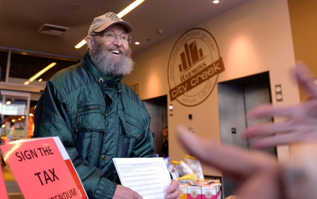 (Leah Hogsten | Tribune file photo) This Jan. 15, 2020, file photo shows volunteer Ron Mortensen at the City Creek Harmons grocery store helping gather voter signatures to put a referendum on the ballot overturning the tax reform package passed by the Legislature. The package included an increase on the food sales tax that was unpopular with grassroots Utahns.