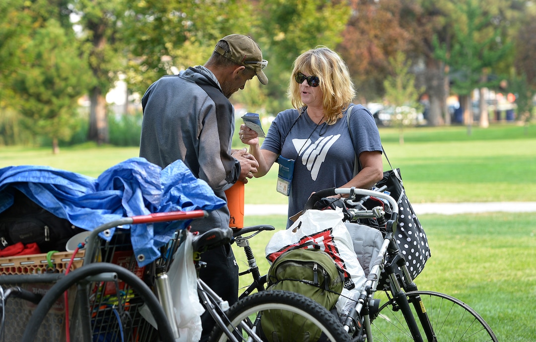 (Scott Sommerdorf   |  The Salt Lake Tribune)   Machele Nieto of the Volunteers of America, hands out some supplies to a homeless man in Fairmont Park, Wednesday, September 6, 2017.
