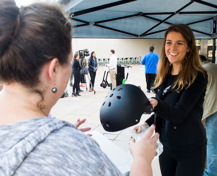 (Rick Egan  |  The Salt Lake Tribune)      Kaitlyn Murray, passes out free helmets courtesy of Bird scooters, at a news conference, about the new campaign with e-scooter companies Lime and Bird in an effort to help residents and visitors understand the rules of the sidewalk, Wednesday, Oct. 3, 2018.


