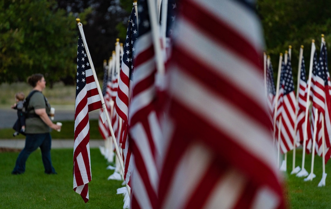 (Francisco Kjolseth | The Salt Lake Tribune) The sun rises on Saturday, Sept. 11, 2021, as people visit the Utah Healing Field in Sandy, part of the nonprofit Colonial Flag Foundation, who posted 3,000 flags to honor the fallen. The display is free to the public and open now through Sept. 13.