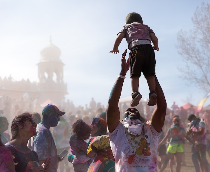(Rachel Rydalch | The Salt Lake Tribune) A man throws up a little boy into the air outside of the Sri Sri Radha Krishna Temple for the Holi Festival of Colors in Spanish Fork on Saturday, March 26, 2022.