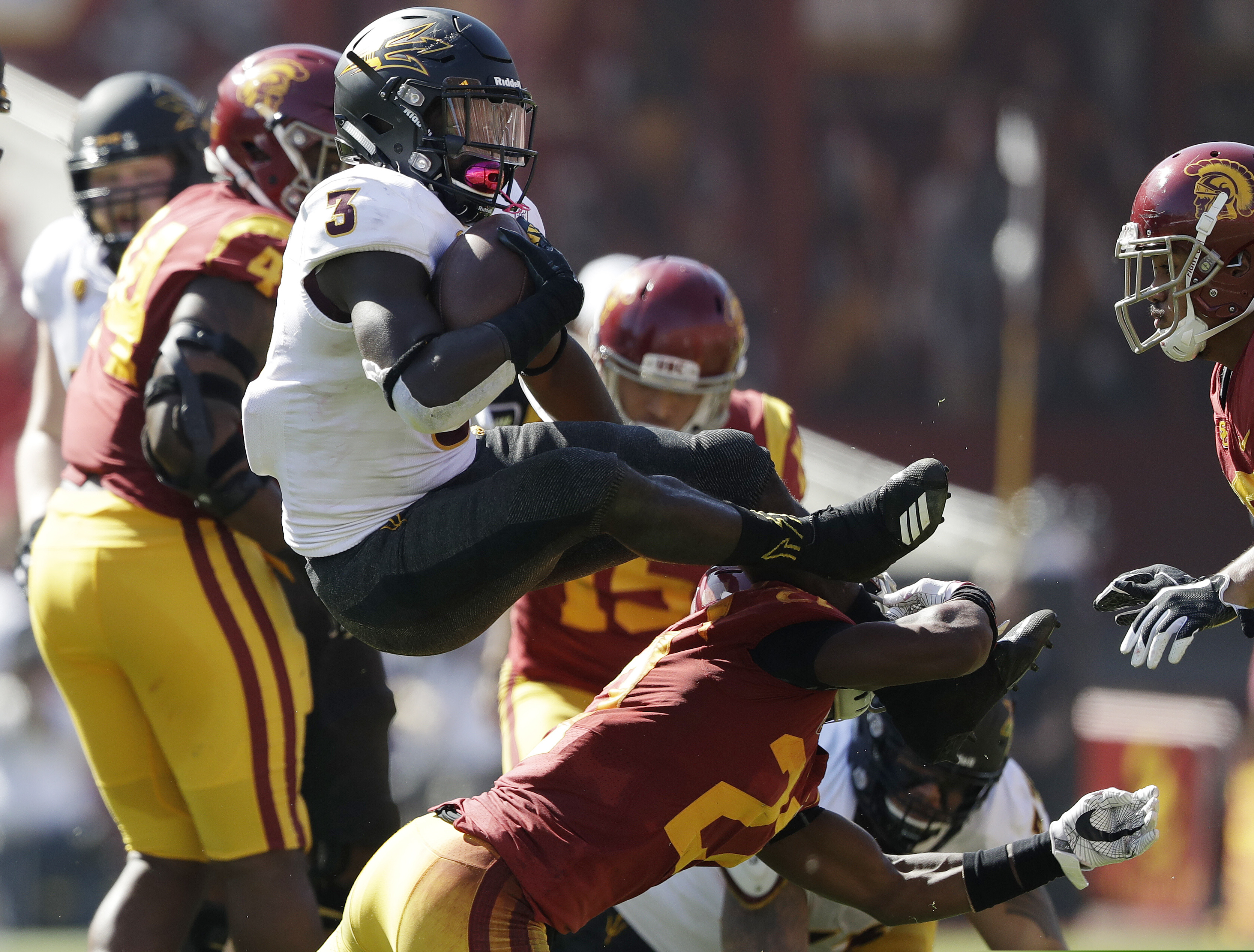 (AP Photo/Marcio Jose Sanchez) Arizona State running back Eno Benjamin (3) leaps over Southern California cornerback Ajene Harris during the first half of an NCAA college football game Saturday in Los Angeles.