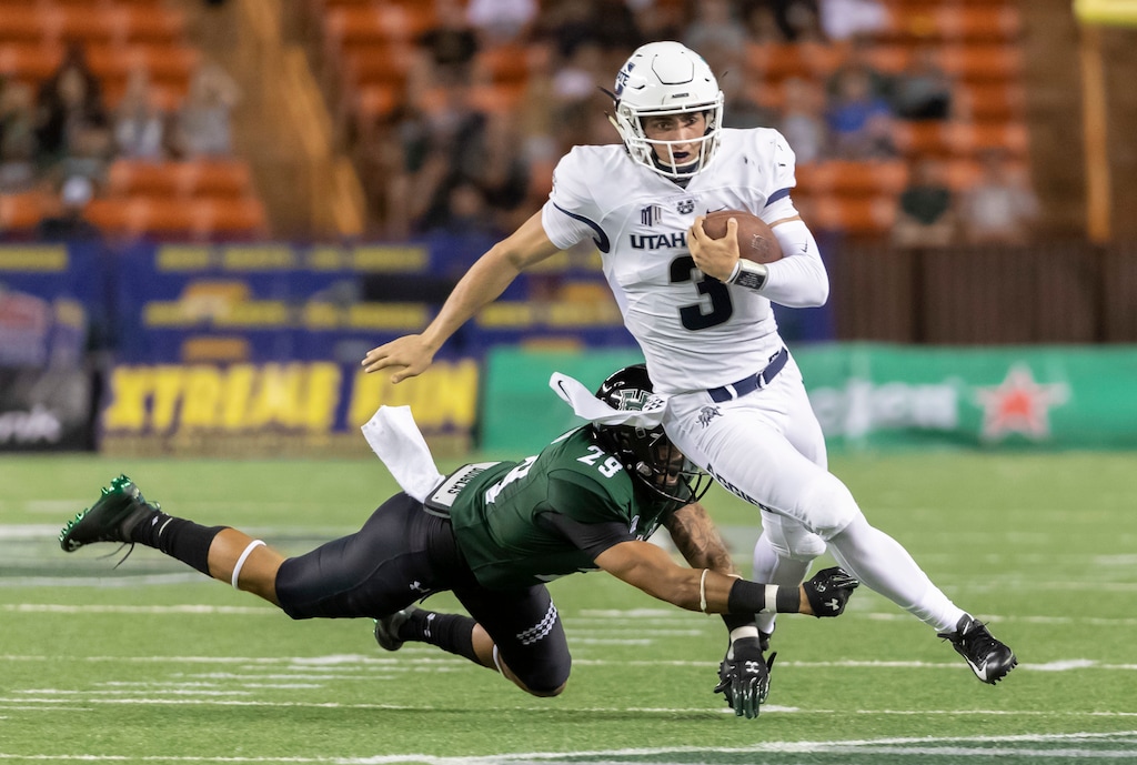 Utah State quarterback Henry Colombi (3) escapes the grasp of Hawaii defensive back Donovan Dalton (29) in the second half of an NCAA college football game, Saturday, Nov. 3, 2018, in Honolulu. (AP Photo/Eugene Tanner)