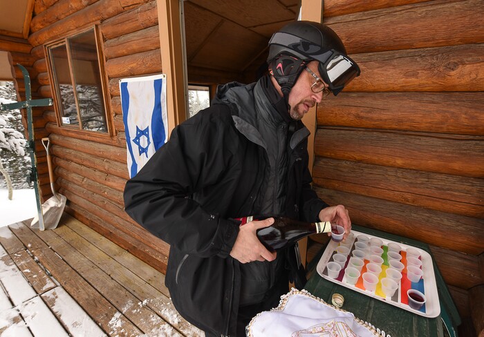 (Francisco Kjolseth | The Salt Lake Tribune) Rabbi David Levinsky, spiritual leader at Park City's Temple Har Shalom, pours small cups of pomegranate wine for Kiddush, a ceremony of prayer and blessing over wine, as he prepares for a service on the upper slopes at Deer Valley Resort. During the winter ski season, Sunset Cabin is the setting for a Friday afternoon Jewish Sabbath service. Jan. 26, 2018.