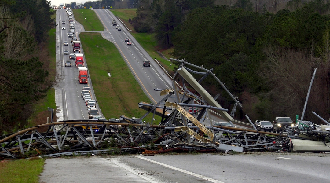 A fallen cell tower lies across U.S. Route 280 highway in Lee County, Ala., in the Smiths Station community after what appeared to be a tornado struck in the area Sunday, March 3, 2019. Severe storms destroyed mobile homes, snapped trees and left a trail of destruction amid weather warnings extending into Georgia, Florida and South Carolina, authorities said. (Mike Haskey/Ledger-Enquirer via AP)