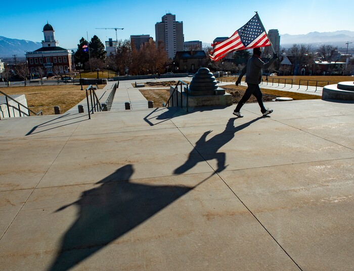 (Rick Egan | The Salt Lake Tribune) Jim White walks back and forth infront of the State Capitol with a tattered American Flag, protesting the corruption politicians and praying that God will change their hearts, on Tuesday Jan. 19, 2021.