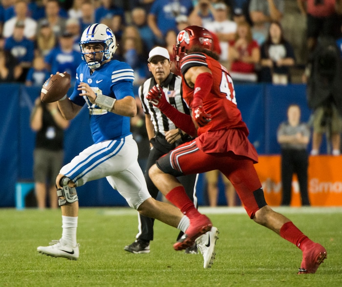(Rick Egan  |  The Salt Lake Tribune)   Brigham Young Cougars quarterback Tanner Mangum (12) is chased by Utah Utes defensive end Caleb Repp (47), football action BYU vs Utah, at Lavell Edwards Stadium in Provo, Saturday, September 9, 2017.