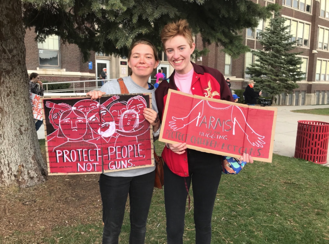 (Lillian Reed | The Salt Lake Tribune) BYU students Emma Barton (left) and Summer Corry (right) pose for a photo with signs they hand made. Both say they march today because better gun regulations have been needed for a long time.