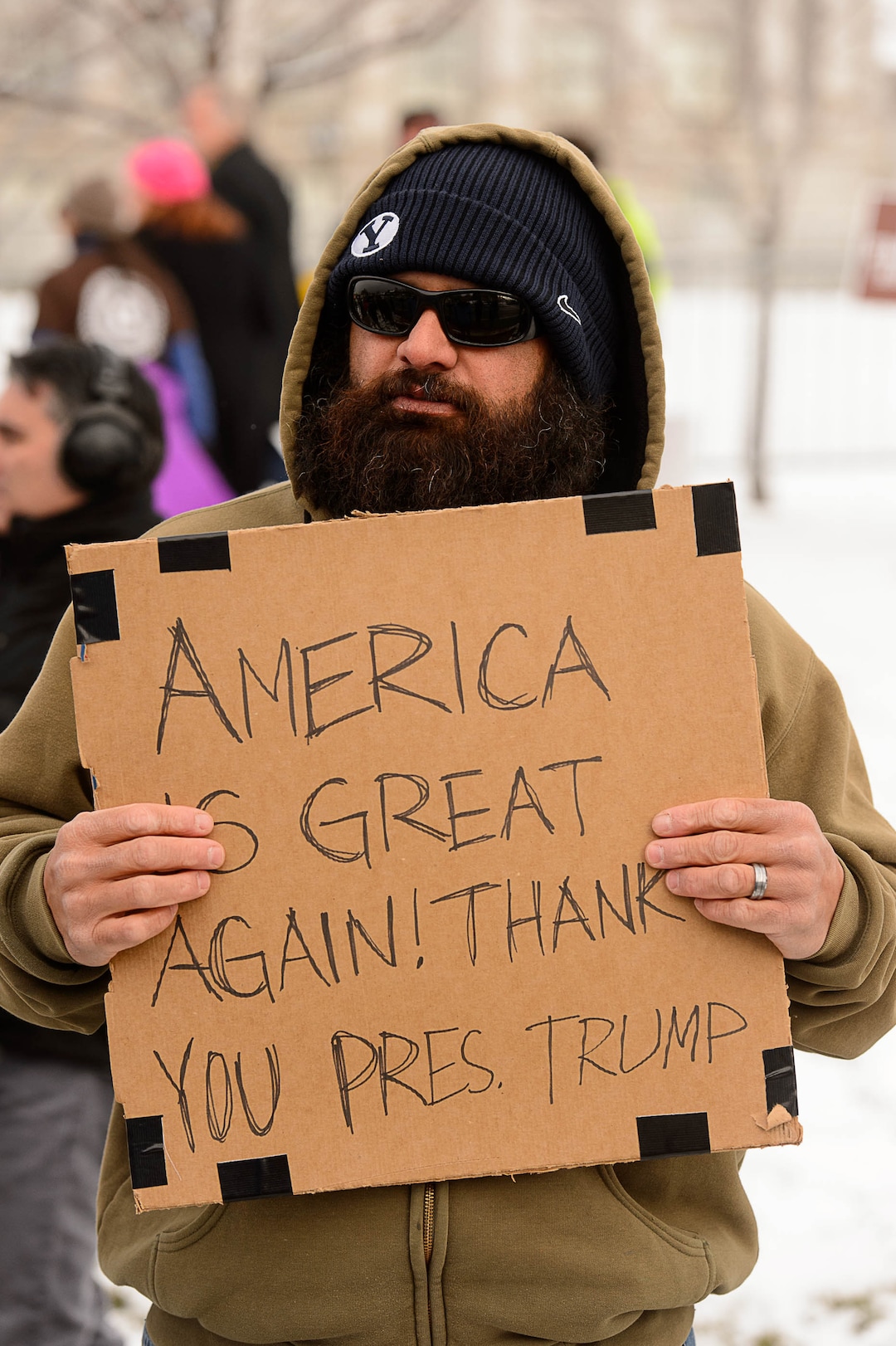 (Trent Nelson | The Salt Lake Tribune)  A man holds a sign supporting Trump as protesters gather before a visit by President Donald Trump, Monday December 4, 2017.