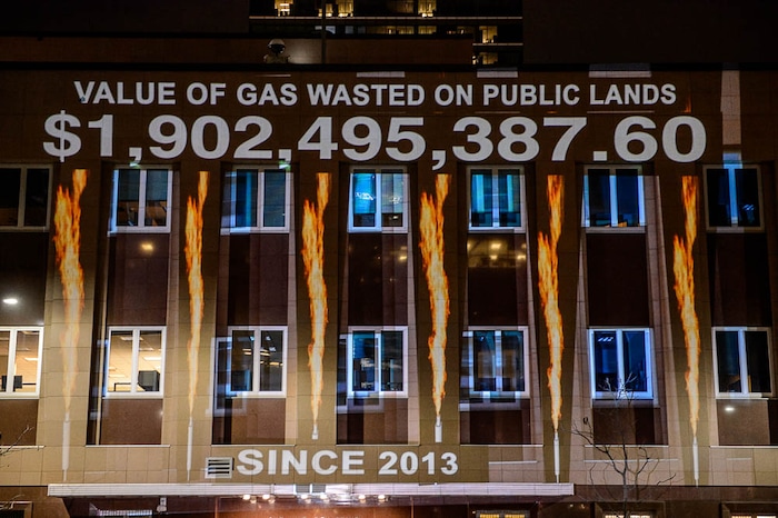 (Trent Nelson | The Salt Lake Tribune)
In a visual protest, Alliance for Better Utah projects the total dollar value of natural gas lost on public lands since 2013 due to venting, flaring, and leaking onto the side of Federal Reserve Building in Salt Lake City, Thursday April 5, 2018.