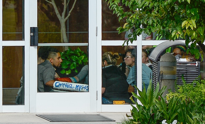 (Francisco Kjolseth  |  The Salt Lake Tribune)  Activists stage a protest against a private prison company with contracts to hold undocumented immigrants on Thursday, July 12, 2018, after locking themselves in the lobby at the headquarters of Management and Training Corporation in Centerville.