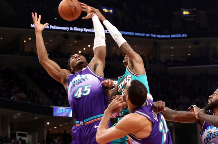 Utah Jazz guard Donovan Mitchell (45) grabs a rebound as Memphis Grizzlies guard Ja Morant (12) defends in the first half of an NBA basketball game Friday, Nov. 29, 2019, in Memphis, Tenn. (AP Photo/Karen Pulfer Focht)