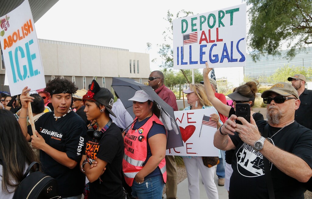 Immigration activists, left, protest against the Maricopa County Sheriff and Immigration and Customs Enforcement at the county jail in an ongoing effort to get immigration authorities out as counter demonstrators gather as well Wednesday, Aug. 22, 2018, in Phoenix. (AP Photo/Ross D. Franklin)
