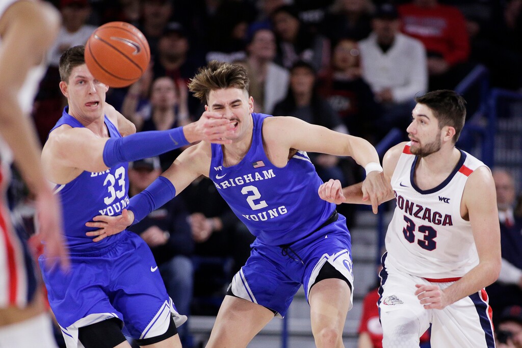 BYU forward Dalton Nixon, left, and guard Zac Seljaas, center, and Gonzaga forward Killian Tillie go after the ball during the first half of an NCAA college basketball game in Spokane, Wash., Saturday, Jan. 18, 2020. (AP Photo/Young Kwak)