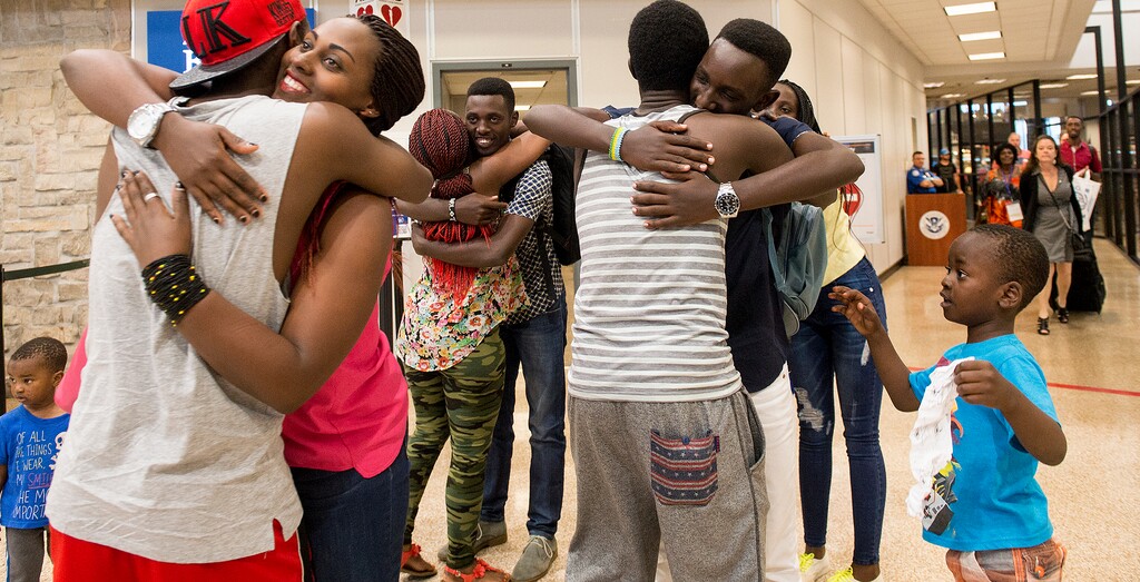 (Leah Hogsten  |  The Salt Lake Tribune)  l-r Adeline Uwicyeza and her brothers Makuza Innocent, center, and Kayrianga Jules, right, are all smiles receiving hugs after their arrival to Salt Lake City with her mother and two other siblings (pictured walking through security at right) from the Democratic Republic of Congo. The Salt Lake City office of the International Rescue Committee welcomed the last refugee family to Utah,  July 6, 2017, before President Donald Trump's 120-day ban on refugees goes into effect.