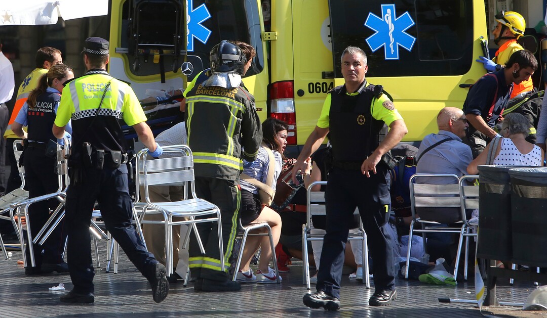 Injured people are treated in Barcelona, Spain, Thursday, Aug. 17, 2017 after a white van jumped the sidewalk in the historic Las Ramblas district, crashing into a summer crowd of residents and tourists and injuring several people, police said. (AP Photo/Oriol Duran)