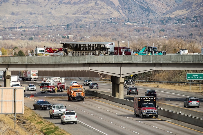 (Chris Detrick  |  The Salt Lake Tribune)  Emergency crews respond to a crashed semi truck hauling cattle on an Interstate 84 overpass in Riverdale Wednesday, November 22, 2017.  While taking the I-15 southbound ramp onto eastbound I-84 at 11:30 a.m., the weight in the semi truck shifted, and the truck tipped over, according to Utah Highway Patrol officials. The truck driver had been speeding, UHP said.