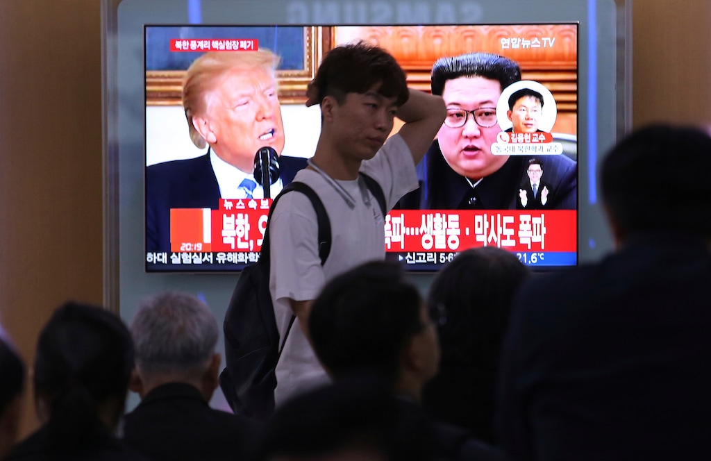 People watch a TV screen showing file footage of U.S. President Donald Trump, left, and North Korean leader Kim Jong Un during a news program at the Seoul Railway Station in Seoul, South Korea, Thursday, May 24, 2018. North Korea carried out what it said is the demolition of its nuclear test site Thursday, setting off a series of explosions over several hours in the presence of foreign journalists.The signs read: " North Korea demolishes nuclear test site ." (AP Photo/Ahn Young-joon)