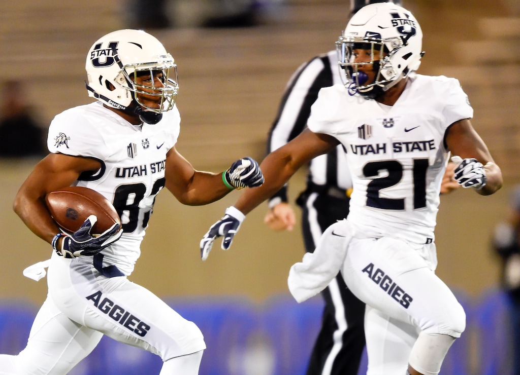 Utah State wide receiver Aaren Vaughns, left, runs the ball for a touchdown against Air Force during an NCAA college football game at Air Force Academy, Colo., Saturday, Nov. 25, 2017. (Dougal Brownlie/The Gazette via AP)