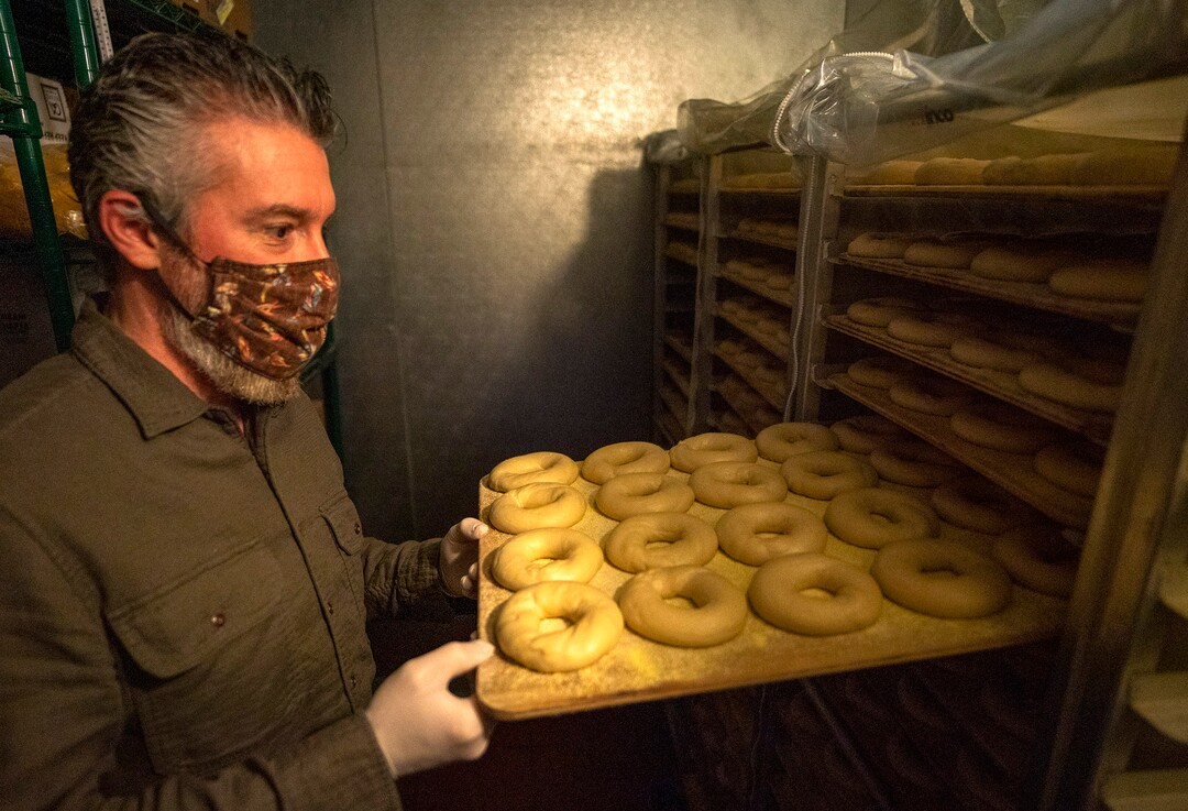 (Rick Egan | The Salt Lake Tribune) Robb Abrams, the owner of The Bagel Project, checks the progress of bagels in the walk in refrigerator, on Tuesday, Jan. 26, 2021.