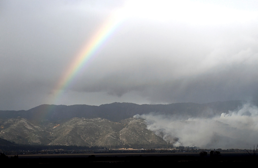 Andy Barron | The Reno Gazette-Journal via AP, File
A rainbow arches over the Little Valley Fire in Washoe Lake, Nev., in 2016. The state of Nevada has reached a tentative settlement with dozens of homeowners and insurance companies that filed an $80 million negligence suit after 23 homes were destroyed when strong winds reignited a prescribed burn south of Reno in 2016. Lawyers for Nevada and more than 60 plaintiffs told a judge in Reno Thursday, May 16, 2019, the state Board of Examiners plans to vote on the settlement agreement June 12.